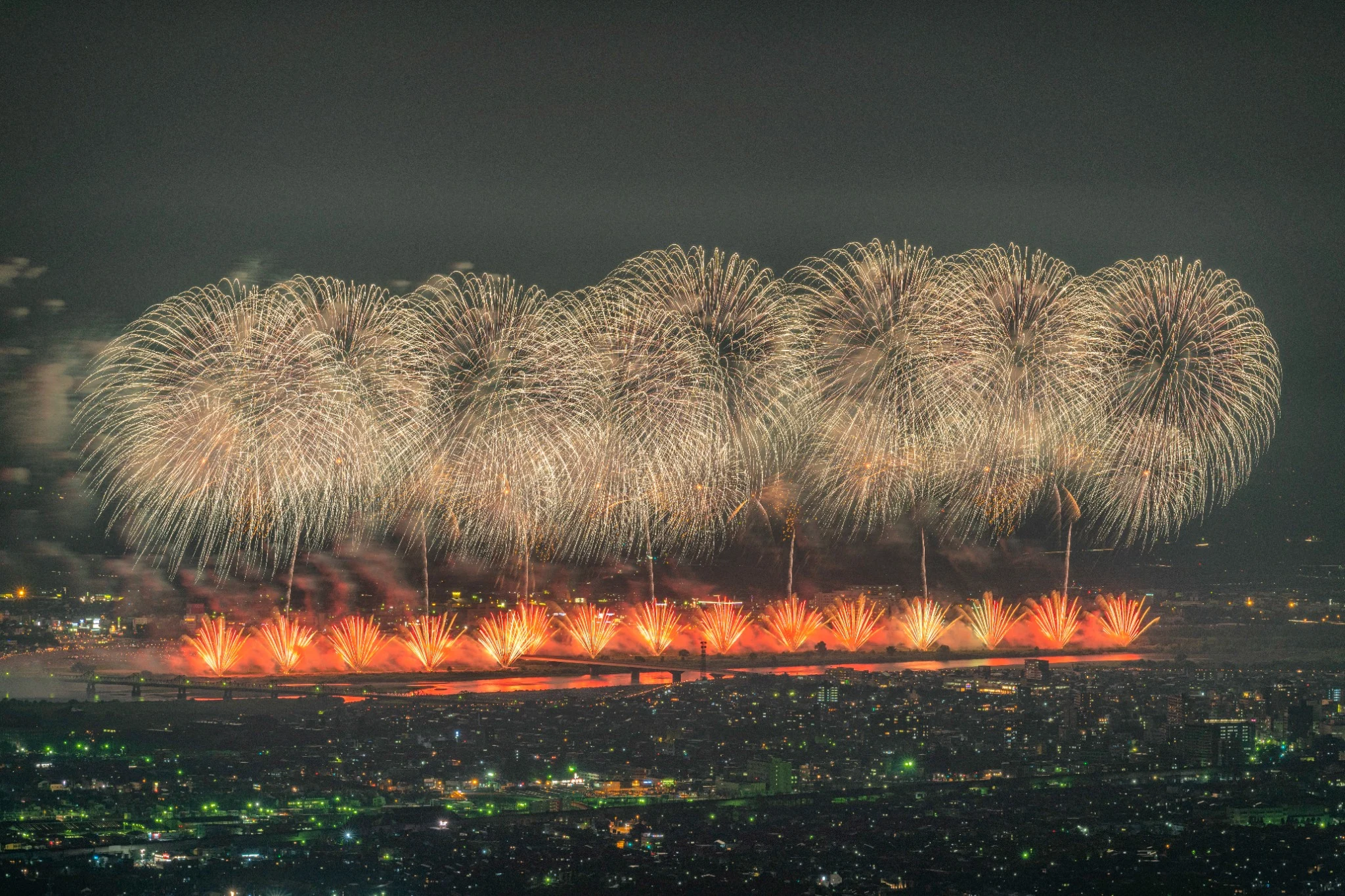 A vast row of golden fireworks illuminating the night sky