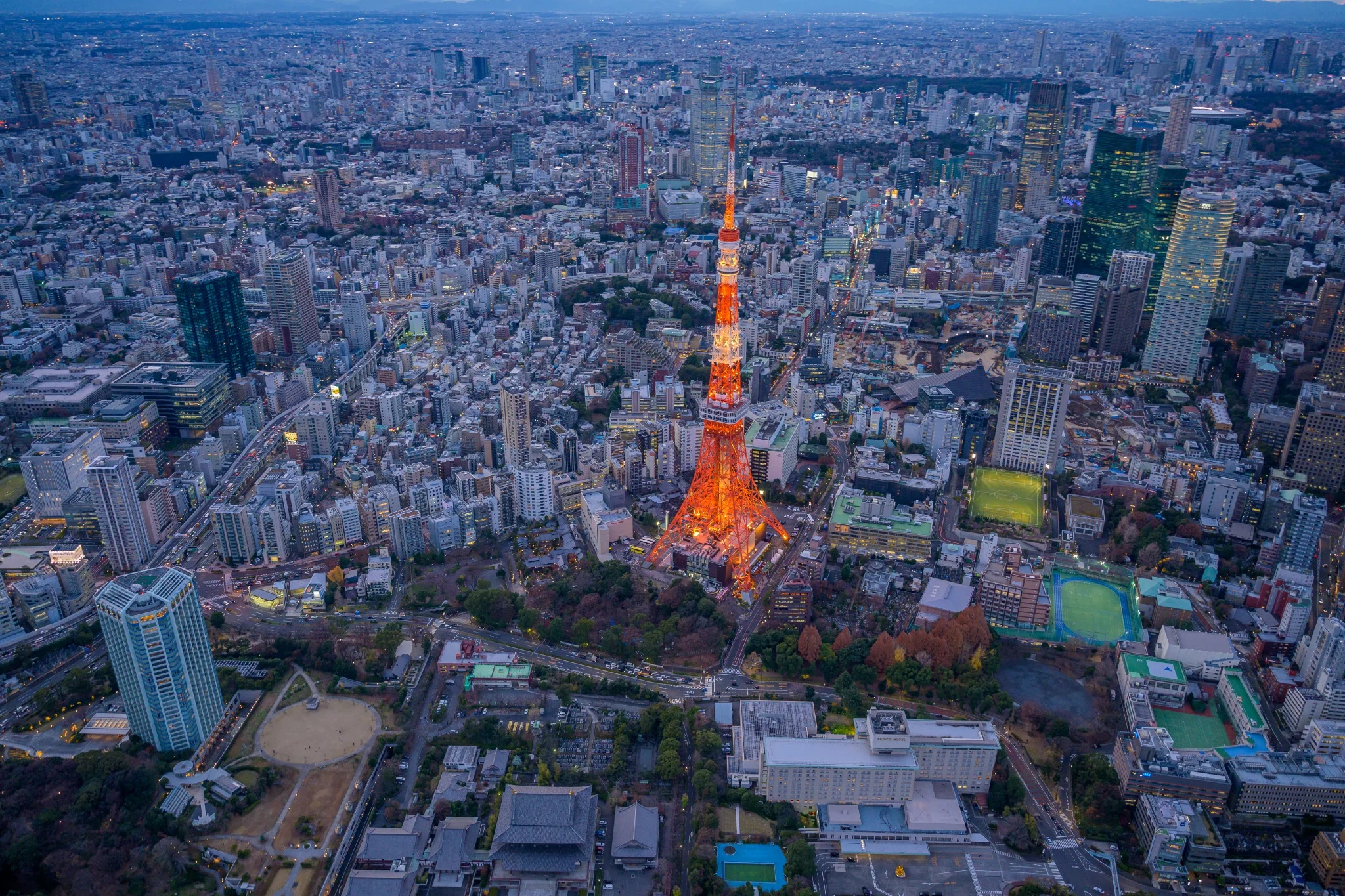 Aerial view of Tokyo Tower illuminated against the city at blue hour